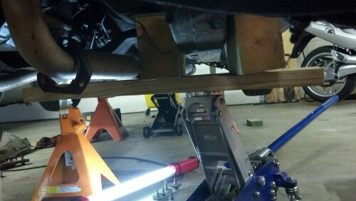 large wooden blocks straddle the subframe to lift the body